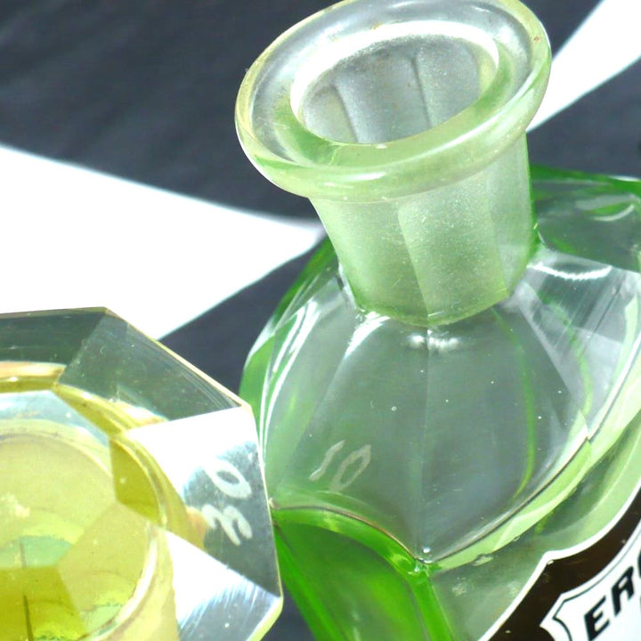 Uranium glass apothecary jar under regular light showing contrasting number etchings.
