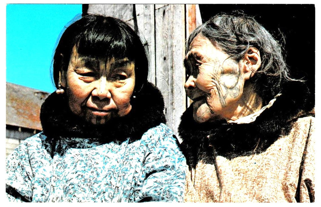 Historical photograph of two Inuit women showcasing traditional facial tattoos (kakiniit) in Alaska