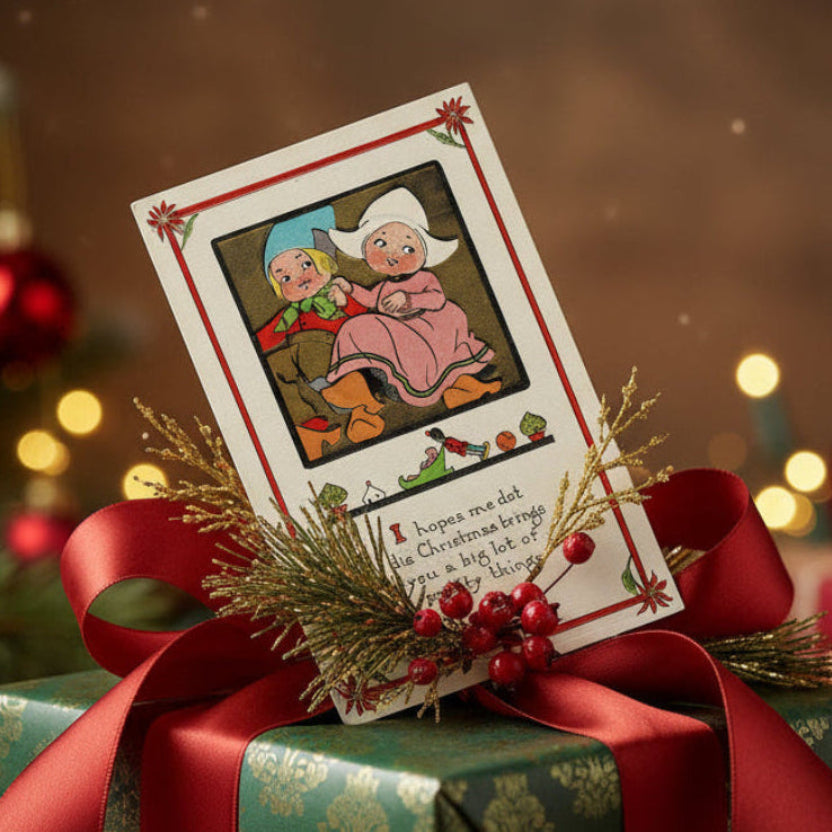 1913 Darling Dutch Children Carry Christmas Greetings Vintage Postcard, shown used as a gift topper.