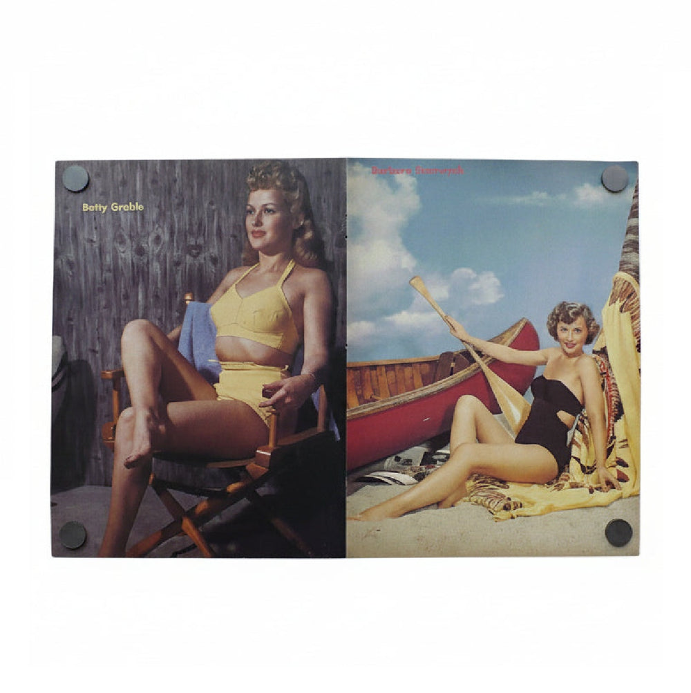 a full page poster of Betty Grable and a full page poster of Barbra Stanwyck joined at magazine fold line.
