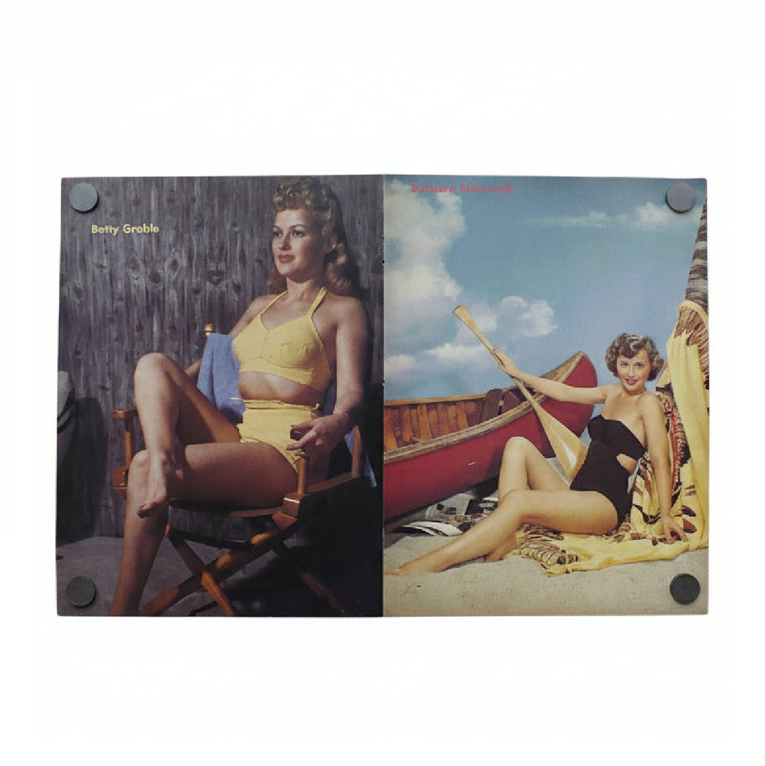 a full page poster of Betty Grable and a full page poster of Barbra Stanwyck joined at magazine fold line.