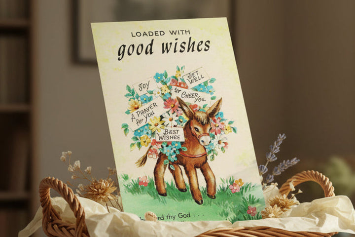 Card with donkey illustration and floral elements on a blurred background.