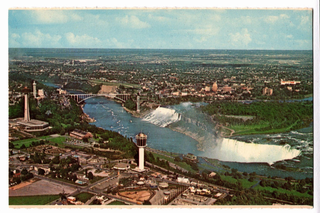 Aerial view of Niagara Falls with a cityscape in the background vintage postcard.