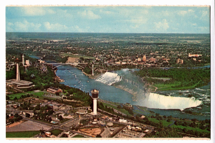 Aerial view of Niagara Falls with a cityscape in the background vintage postcard.