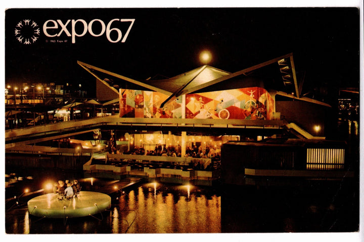 Expo 67 pavilion at night with illuminated sign and architectural design.