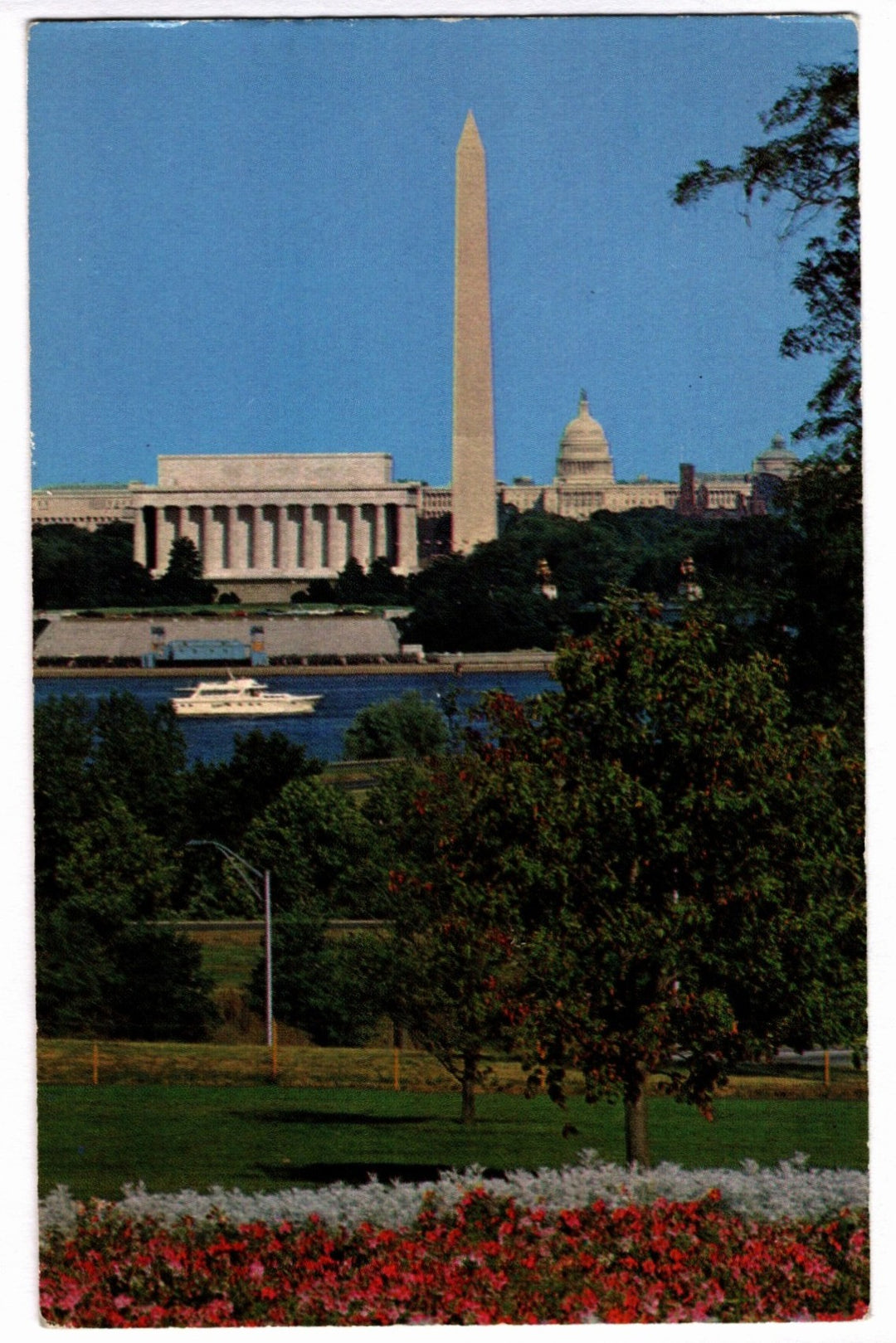 View of the Washington Monument and National Mall with a boat on the Potomac River.