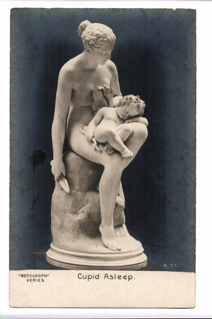 Statue of a woman holding a child labeled 'Cupid Asleep' on a dark background