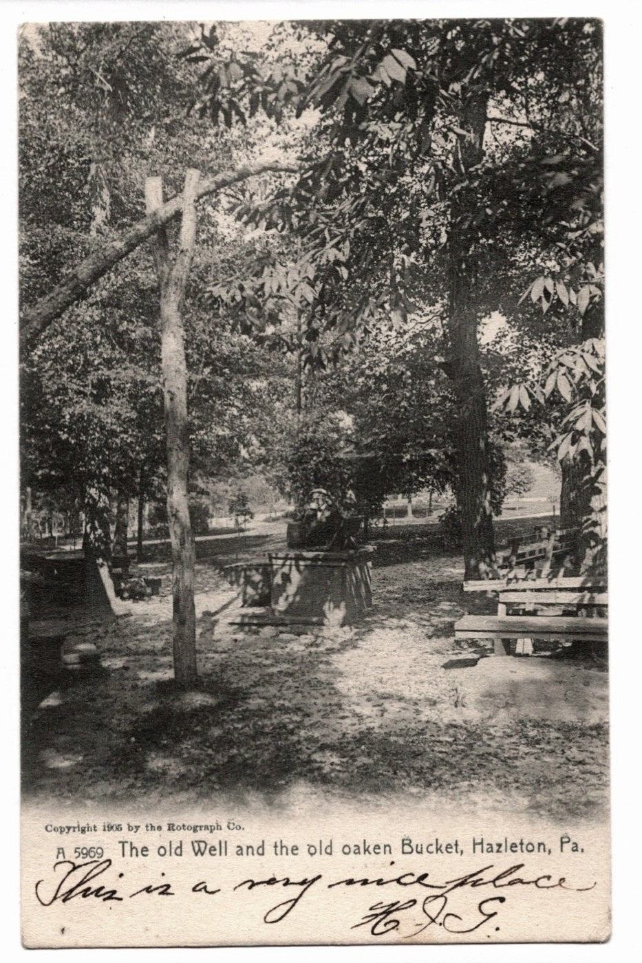 Vintage postcard of a well and bucket in a park with trees and benches. 1906 Hazleton Pennsylvania Old Well Rotograph Vintage Postcard UDB.