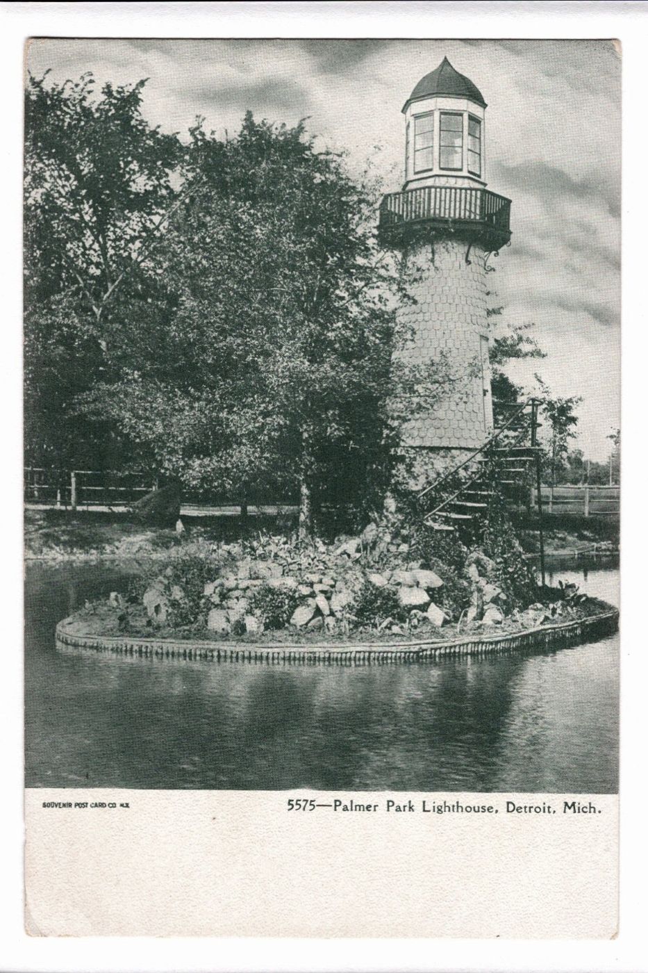 Vintage black and white postcard of a lighthouse on an island in a pond with trees in the background. 1900s Palmer Park Lighthouse Detroit Michigan Vintage Postcard UDB.