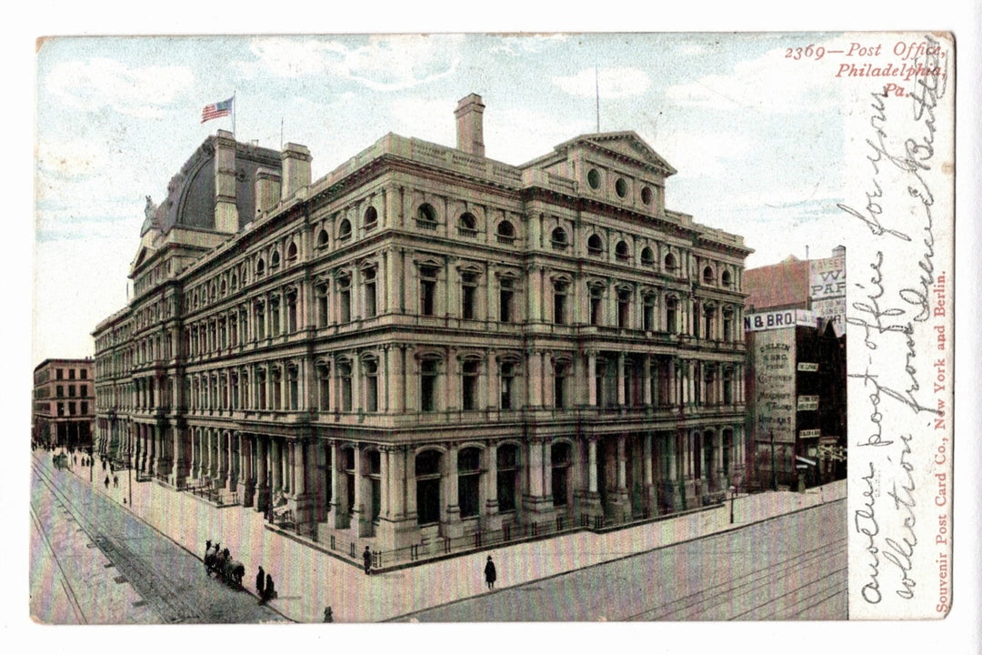 Vintage postcard of a large building with people and vehicles on a street, featuring an American flag. 1900s Philadelphia Post Office Pennsylvania Vintage Postcard UDB.