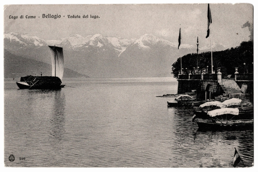 Vintage black and white image of a lake scene with boats and mountains. 1900s Lake Como Bellagio Veduta del Lago Vintage Postcard UDB.