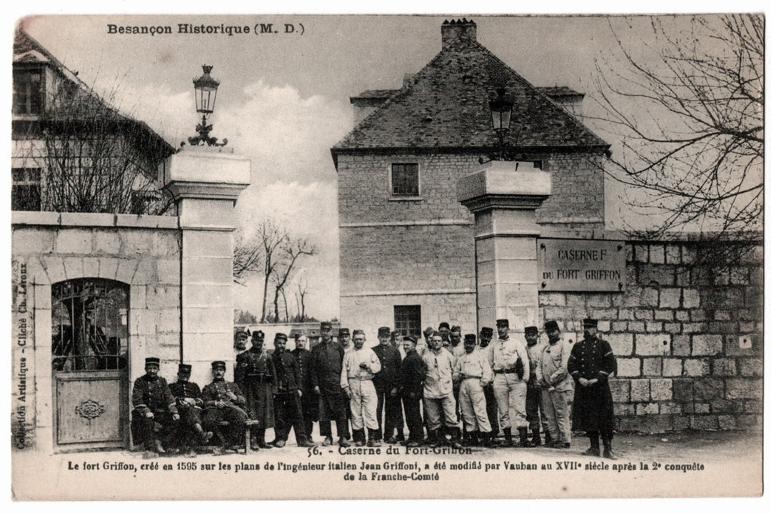 Monochromatic postcard features a historical image of the Caserne du Fort-Griffon in Besançon, France. The scene captures a large group of French soldiers standing and seated in front of the fortified entrance to the barracks. The soldiers are shown in their period military attire, including the characteristic képis and tunics of the early 20th-century French Army.