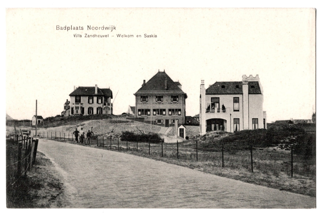 This antique monochromatic postcard features a scenic view of the seaside resort (Badplaats) of Noordwijk in the Netherlands. The image captures several grand villas situated on the dunes, including the identified Villa Zandheuvel, Villa Welkom, and Villa Saskia. A brick road winds through the foreground, with several figures standing near a fence line. 