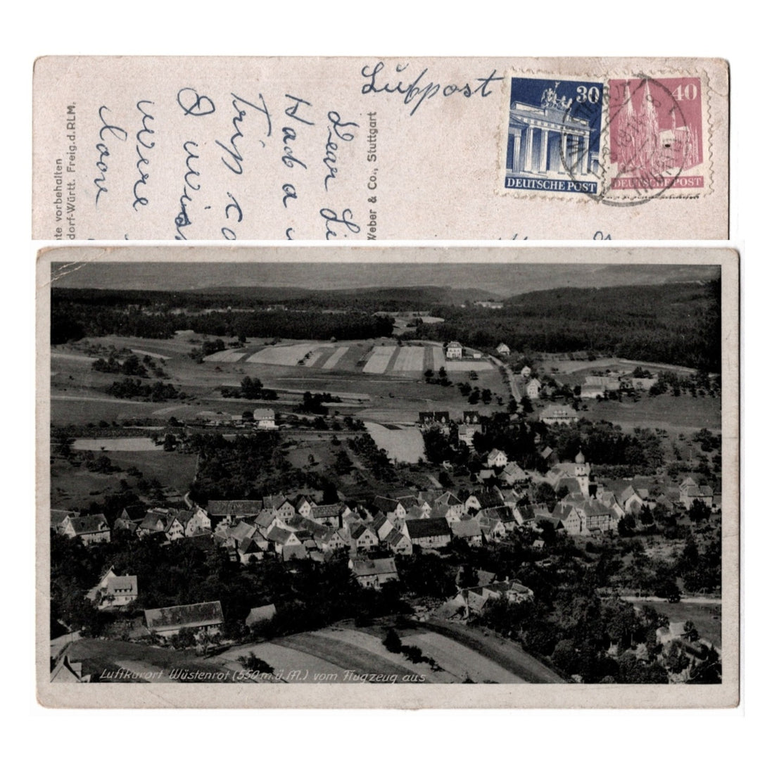 Vintage postcard with aerial view of a village and German postage stamps.