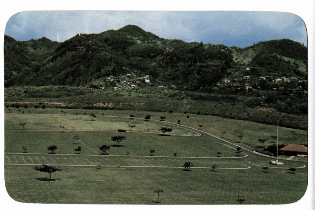 Scenic view of a grassy area with trees and mountains in the background, 1954 National Memorial Cemetery Honolulu Hawaii Vintage Postcard.