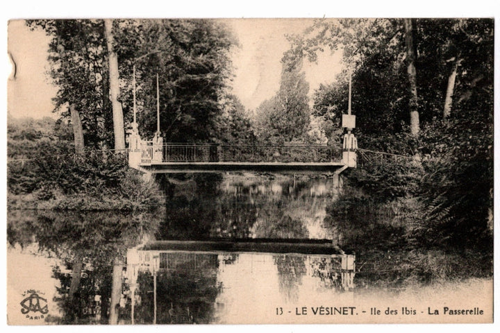 A suspension bridge over a pond with trees on either side. 1910 Le Vesinet Ibis Island Footbridge France Vintage Postcard.