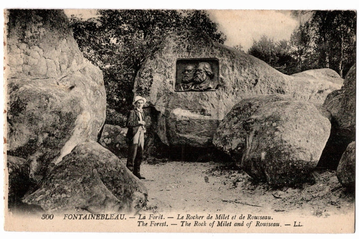 Vintage postcard of a person standing next to large rocks with a carved face, labeled 'La Forèt' and 'The Rock of Milet and de Rousseau'.