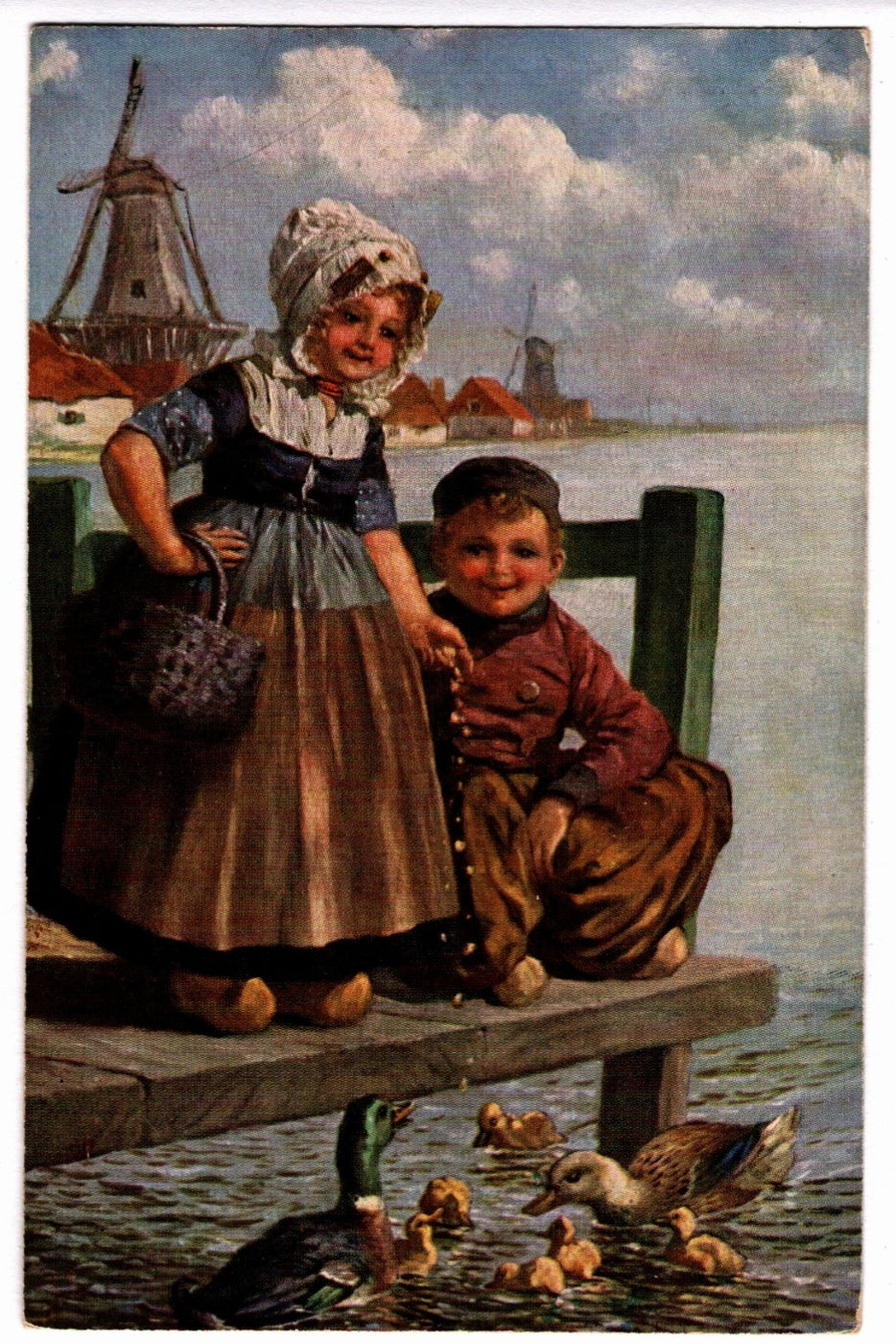 Children by a dock with ducks and windmills in the background. 1908 Dutch Children Feeding Ducks Vintage Art Postcard.