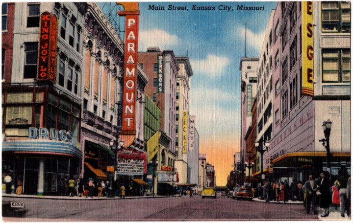 Vintage postcard of Main Street, Kansas City, Missouri with prominent buildings and signage.