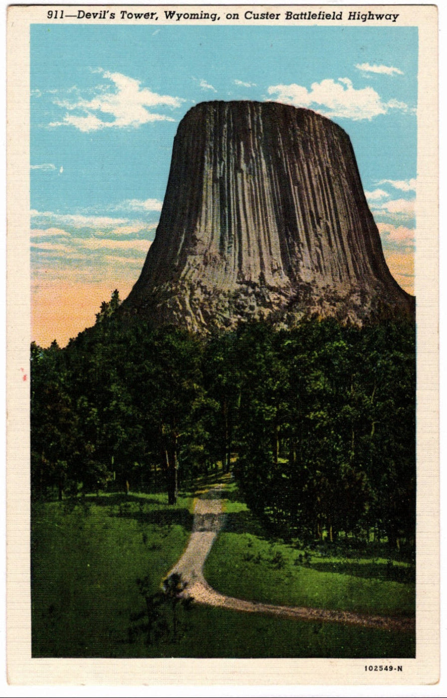 Vintage postcard of Devil's Tower, Wyoming, with a clear sky and trees.