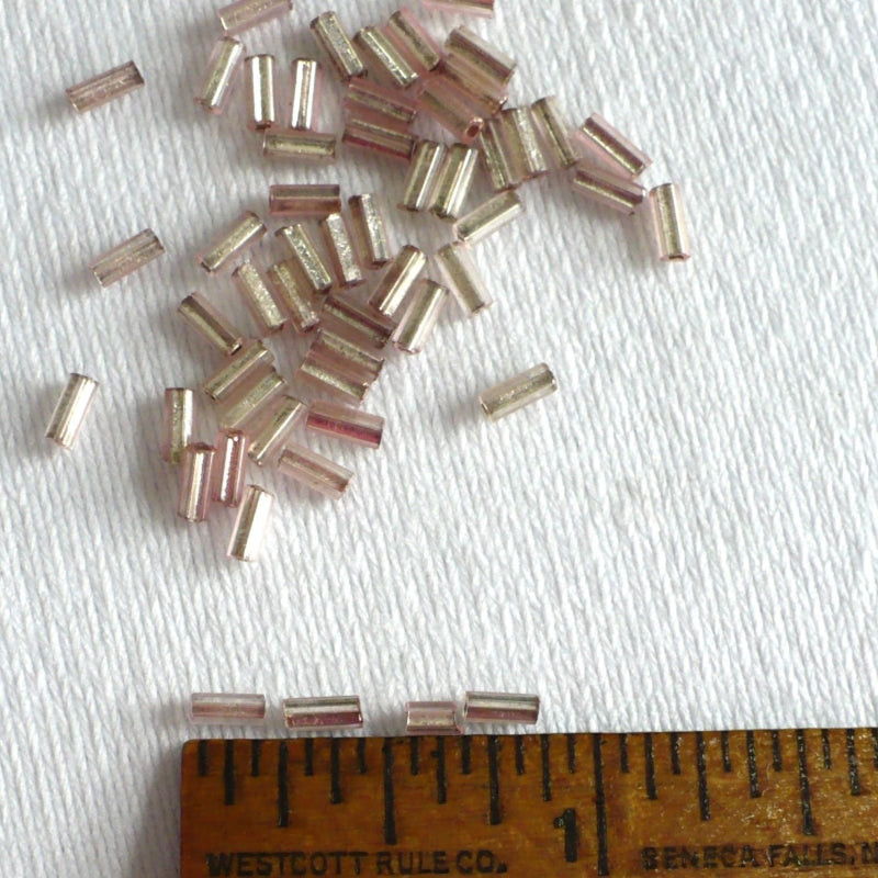 1920s Pink Mercury Glass Bugle Beads next to a ruler for scale.