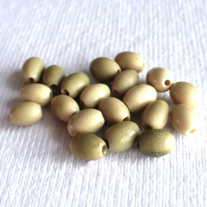 Batch 1910s 5x7mm Smooth Oval Vegetable Ivory Beads shown at an angle.- view 2.