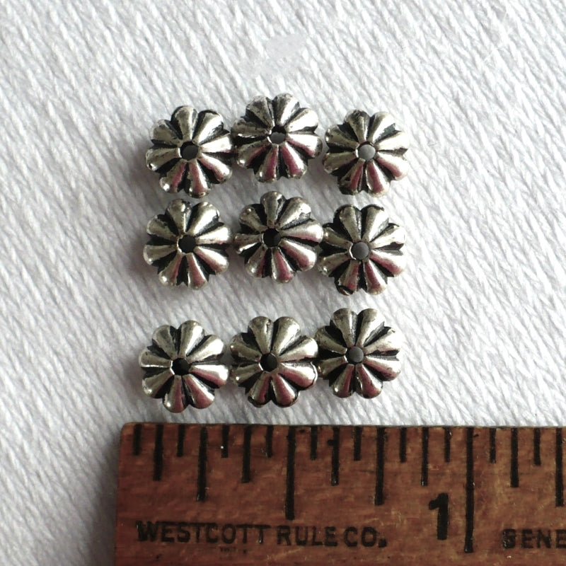 1960s Silver Flower Spacer Beads, close-up, on a white fabric background next to a ruler for scale.