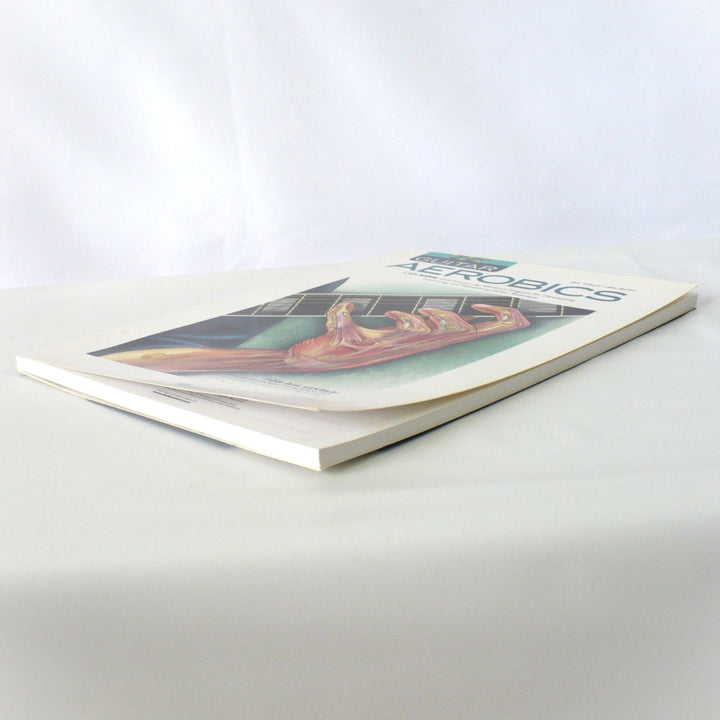 Angled view of the Guitar Aerobics book, highlighting the thickness and quality of the instructional program and its accompanying audio CDs.