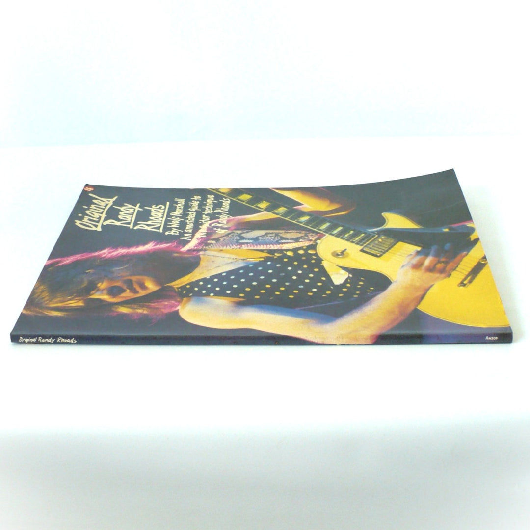 Spine view of the 1986 Original Randy Rhoads guitar book showing the Amsco logo and excellent, uncreased condition of the binding.