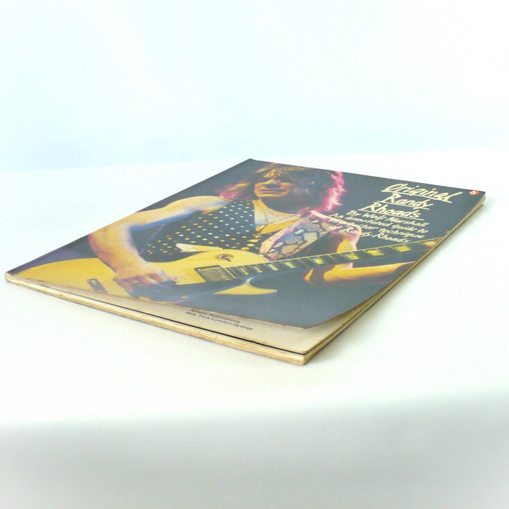 Perspective view of 1986 Original Randy Rhoads guitar book showing the Amsco Publications imprint and minor storage curve at the lower corner.