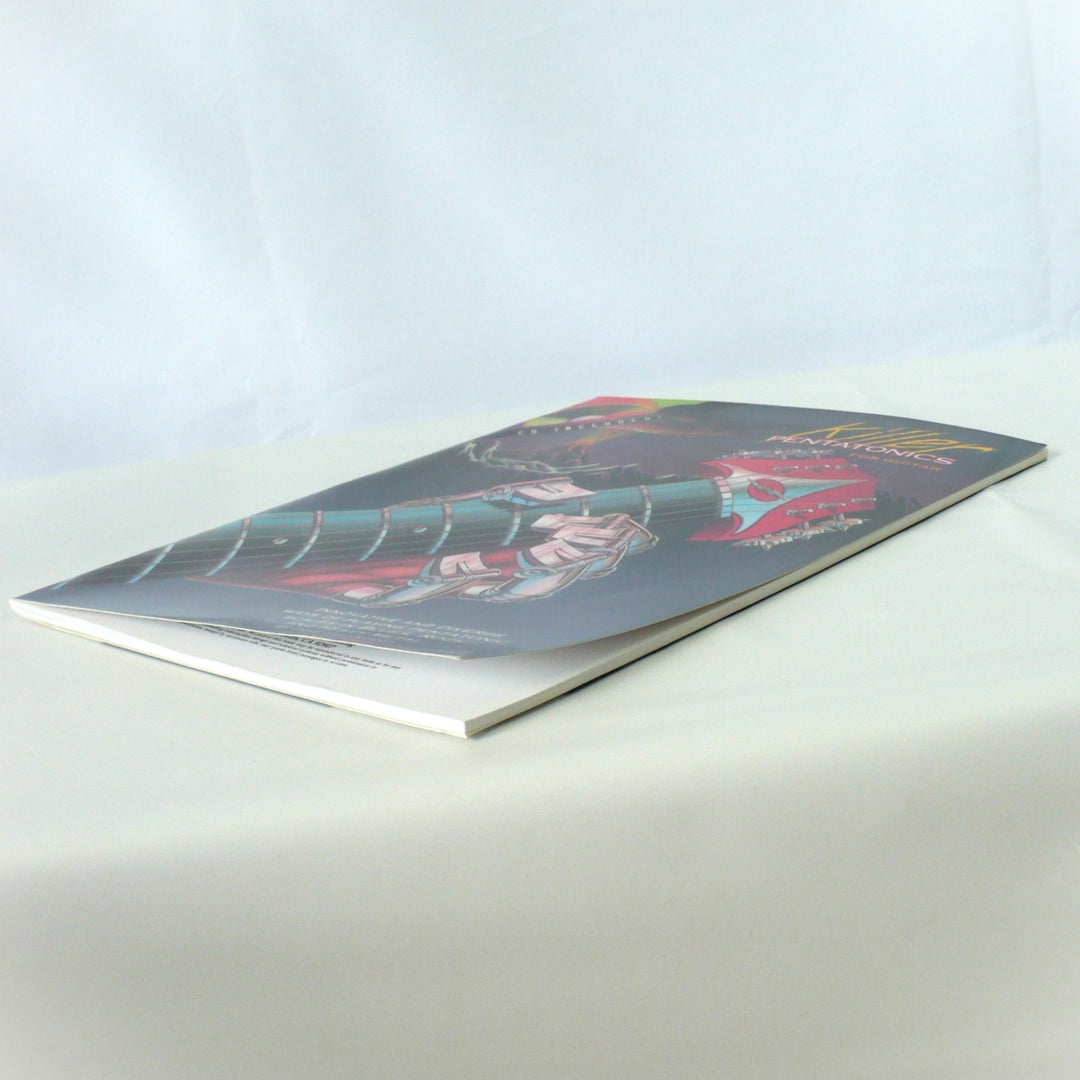Side angle view of 'Killer Pentatonics for Guitar' showing the book's profile and slight shelf curl on the cover, confirming authentic vintage condition.
