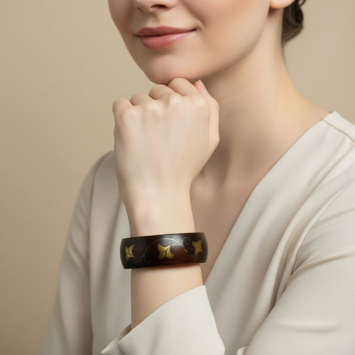 970 Vintage Brass Vine Inlay Teak Bangle Bracelet on woman's wrist.
