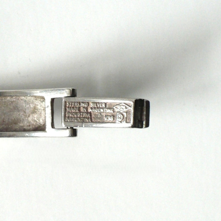 A close-up of a sterling silver metal clasp or hinge component, showing engraved text that reads 'STERLING SILVER MADE IN ARGENTINA' on a plain white background.