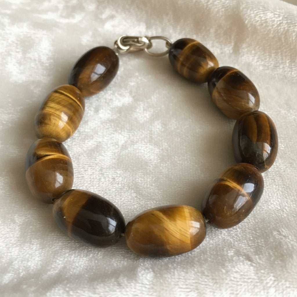 Bracelet with tiger eye stones on a cream colored velvet  background.