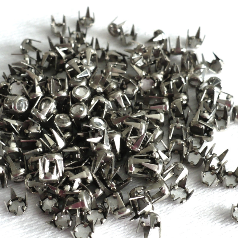 1940s Vintage Rhinestone Brads Studs 4mm grouping on white fabric.
