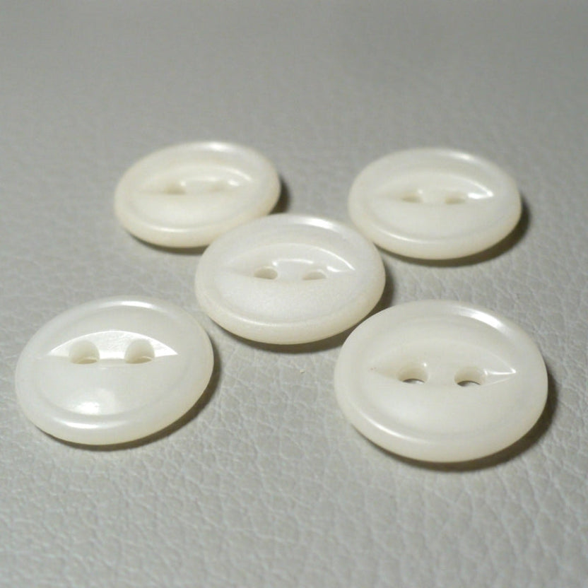 22L Set of Five White Celluloid Two Hole Fish Eye Buttons, view from angle, on textured grey background.