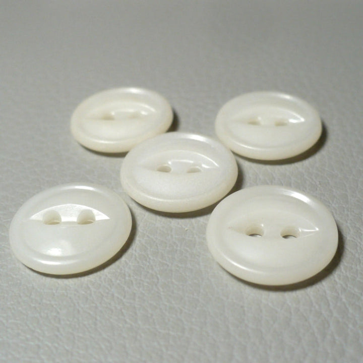 22L Set of Five White Celluloid Two Hole Fish Eye Buttons, view from angle, on textured grey background.