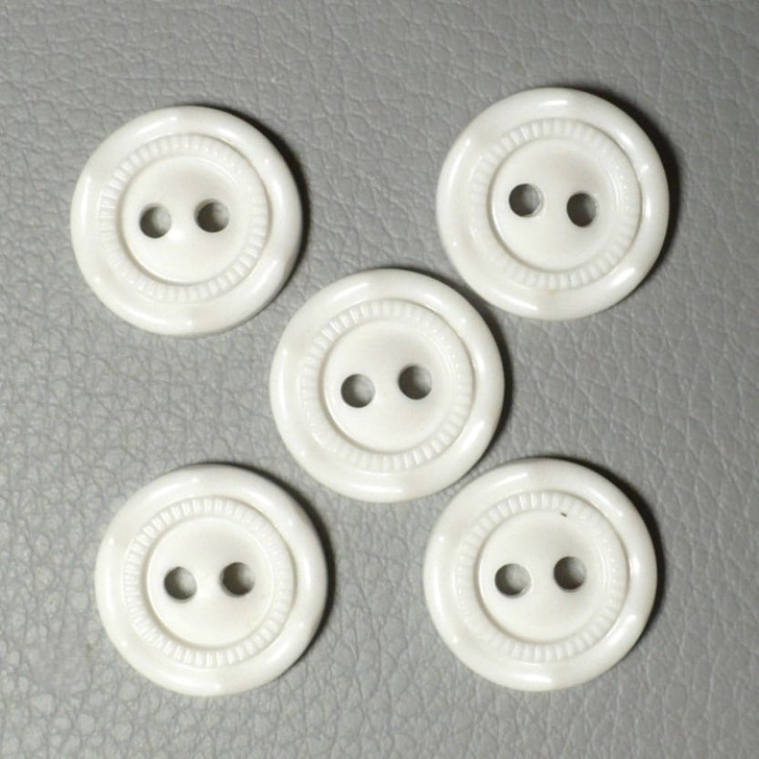 24L Set of Five Opaque White Celluloid Two Hole Buttons .on a textured gray surface.