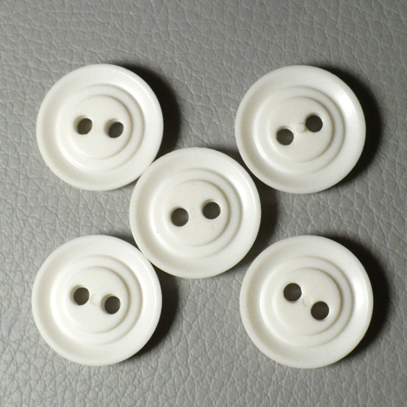 View of the backs of  Set of Five Opaque White Celluloid Two Hole Buttons, on gray background.