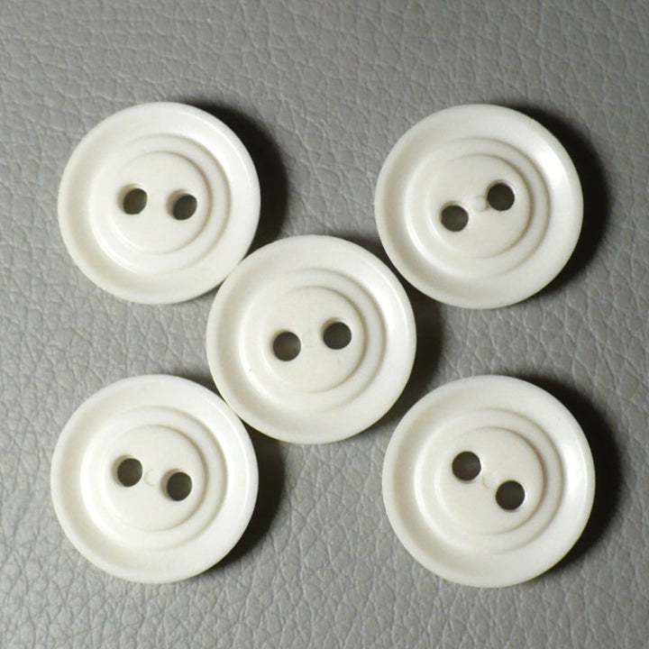 View of the backs of  Set of Five Opaque White Celluloid Two Hole Buttons, on gray background.