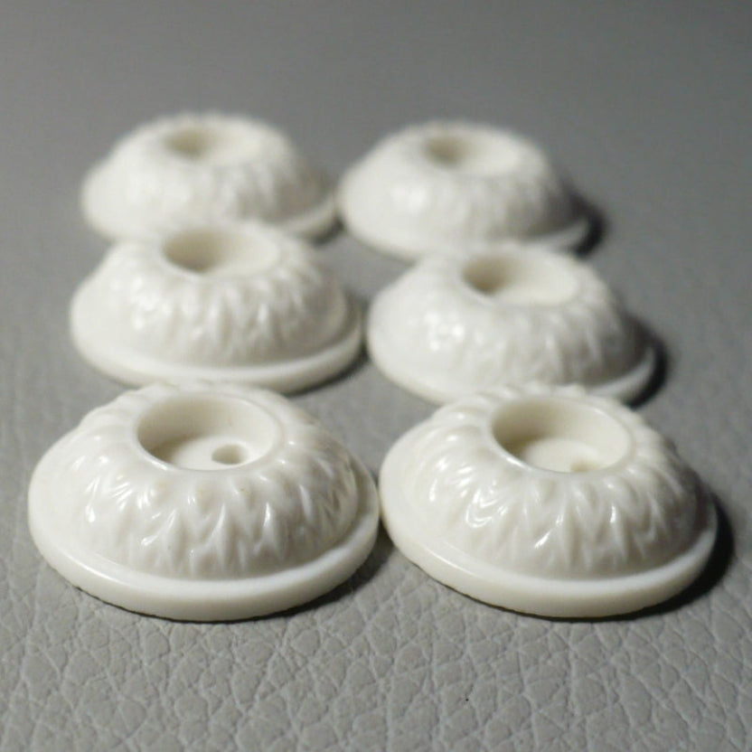 23L Set of Six White Celluloid Whistle Buttons, side view on gray background.