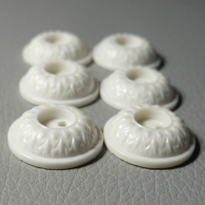 23L Set of Six White Celluloid Whistle Buttons, side view on gray background.