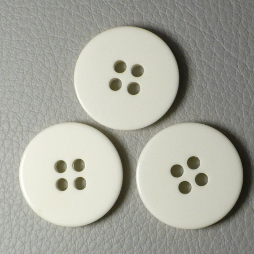 30L Set of Three Pearly White Layered Four Hole Buttons, 3/4", fronts. arranged on a textured gray background arranged in a triangle on a textured gray surface.
