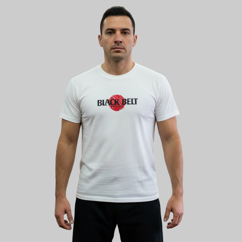 Man wearing a vintage 1980s white t-shirt with 'Black Belt' logo with plain background.