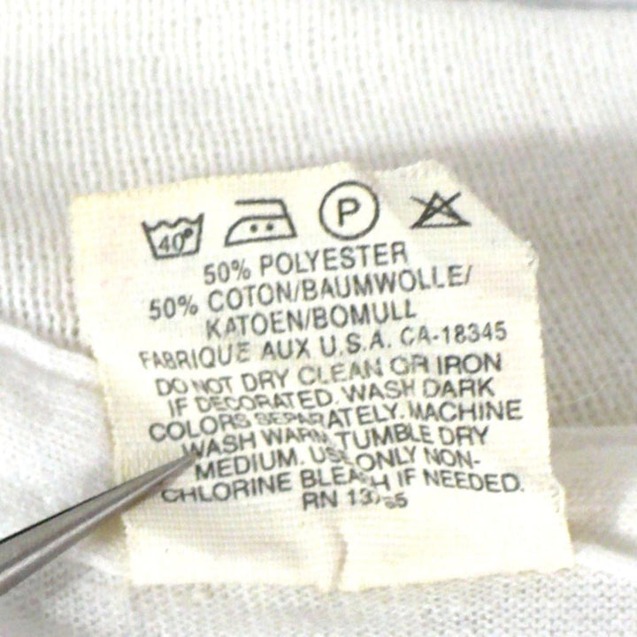 Vintage 1980s white t-shirt with 'Black Belt' logo, enlarged image of care instructions found on back of tag.