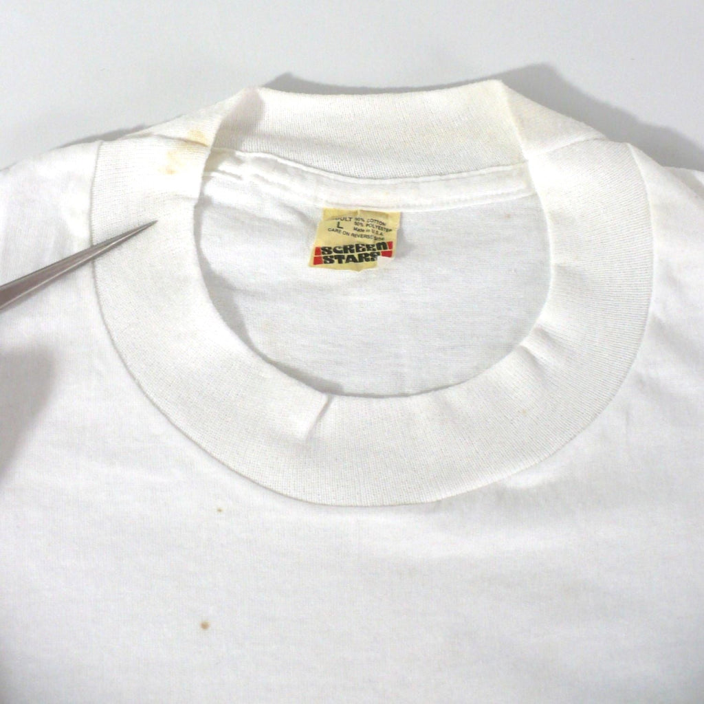 Vintage 1980s white t-shirt with 'Black Belt' logo, enlarged image showing stains at front and collar, on a white table top background.