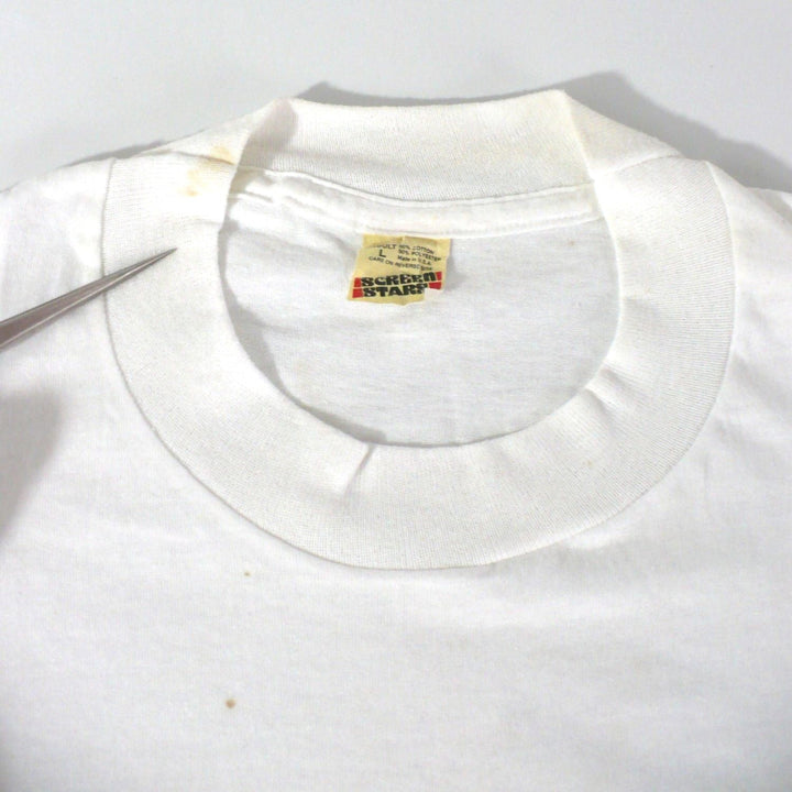 Vintage 1980s white t-shirt with 'Black Belt' logo, enlarged image showing stains at front and collar, on a white table top background.