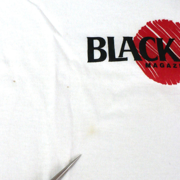 Vintage 1980s white t-shirt with 'Black Belt' logo, enlarged image showing stains at front, on a white table top background.