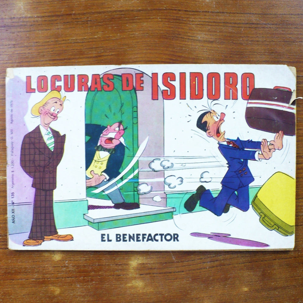 A vintage Spanish comic book titled 'LOCURAS DE ISIDORO' on a wooden table.