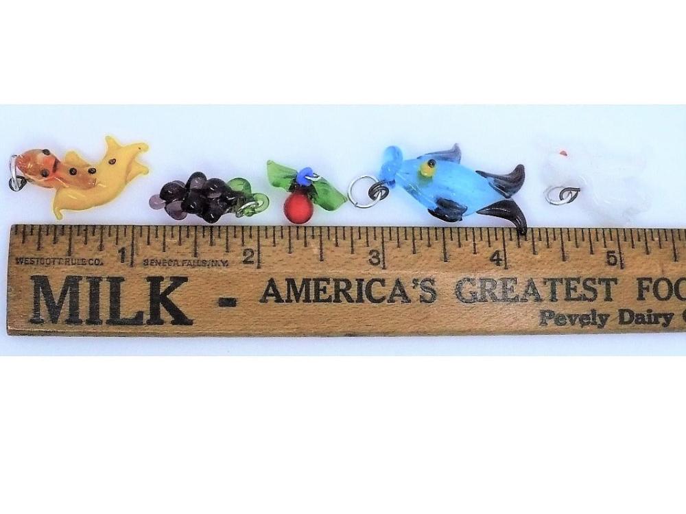 1960s vintage lampwork charms: a white elephant, a salamander, a fruit, a heart, a blue fish, and a grape cluster.